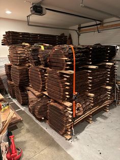 several stacks of wood stacked on top of each other in a garage next to a red fire hydrant