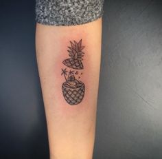 a small pineapple tattoo on the arm