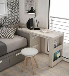 a bedroom with a bed, desk and bookcases in front of a window