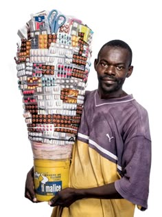 a man is holding a large stack of items