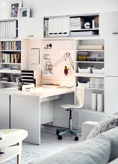 an office with white furniture and lots of shelves