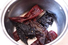 some red peppers are in a silver bowl