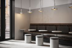 an empty restaurant with white tables and gray chairs next to a large glass door that leads out onto the street