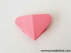 a pink origami heart on a white background