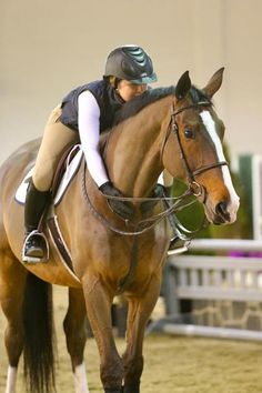 a woman riding on the back of a brown horse