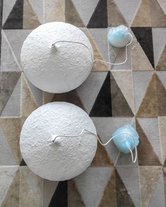 two white round objects sitting on top of a floor next to each other with wires attached to them