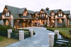 a large house with lots of windows and stone pillars on the front entrance to it