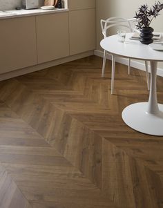 a white table sitting in front of a window on top of a hard wood floor