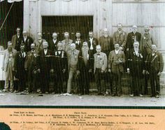 an old black and white photo of men in front of a building