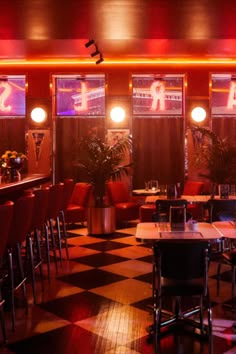 an empty restaurant with checkered floor and red lighting