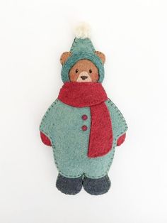 a teddy bear wearing a blue coat and red scarf