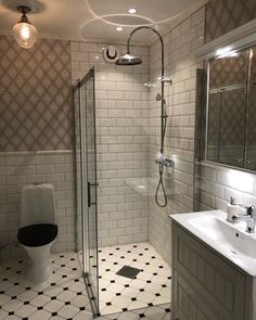 a bathroom with a toilet, sink, and shower stall in it's corner