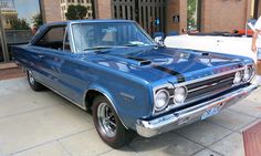 an old blue car parked in front of a building