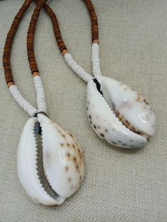 The necklace is a large 3 inch Cowrie Shell. It is beaded with 8 mm wood beads. The necklace is available in multiple lengths. If you have any questions please feel free to contact us at anytime. All shipping options are available. All items will be shipped out Monday through Friday. Receipts will be emailed out for immediate access. All items will be shipped out carefully and every shipment can be made with extra insurance upon request. All other concerns and details can be found in our policy section. Our goal is for your 100% satisfaction. If you would like to make a large order please contact us for a coupon code. Our products are not intended for babies or children as we use small pieces, wires and beads. These can be dangerous to them when unsupervised. Gift boxes and gift messages a Africa Beach, Loc Jewelry, Seashell Jewelry, Ethnic Necklaces, Crystal Healing Stones, Diy Wire Jewelry, Shell Necklace, Bracelets Handmade Beaded, Shell Jewelry