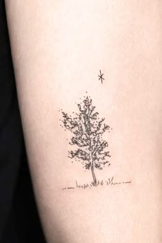 a small tree tattoo on the right side of the thigh, with stars above it