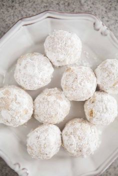 a white plate topped with snowball cookies