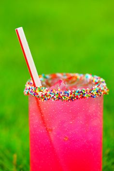 a pink drink with sprinkles and a straw