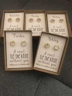 four pairs of earrings in boxes on a couch with the words i can't be the knot attached to them