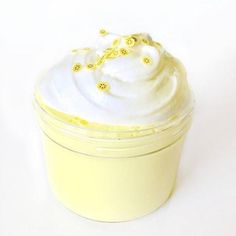 a yellow container filled with whipped cream on top of a white table