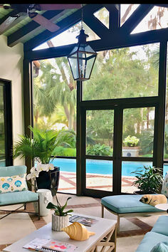 a living room filled with furniture next to a swimming pool