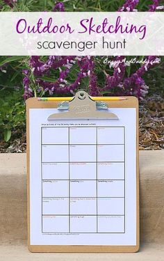 a wooden clipboard with an outdoor sketching scavenger hunt on it and purple flowers in the background