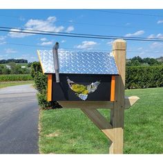 a mailbox sitting on the side of a road next to a grass covered field