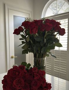 a vase filled with red roses on top of a table