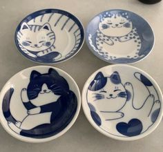 four blue and white plates with cats on them