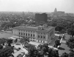 an aerial view of a large building in the middle of a city with tall buildings