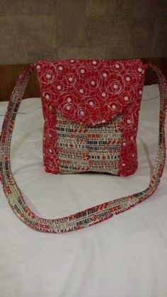 a red purse sitting on top of a white bed