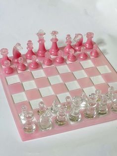 a pink and white chess board with glass pieces