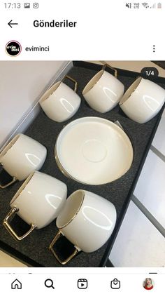 the table is set with white dishes and silverware on it's black tray