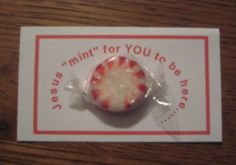 a small piece of fruit wrapped in plastic on top of a wooden table next to a card