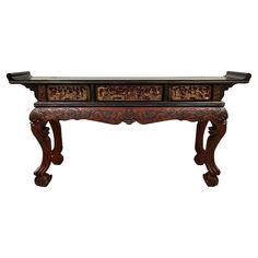 an ornate wooden table with two drawers