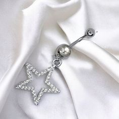 a pair of dangling stars on a white satin fabric with a jeweled ball in the center