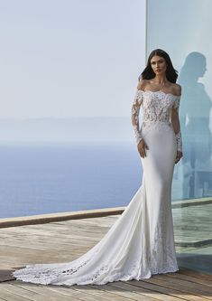 a woman in a wedding dress standing on a deck