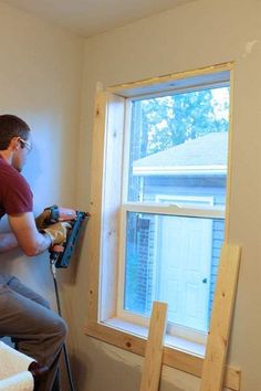 a man is working on the window sill