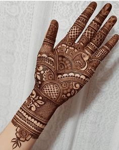 the hand is decorated with henna on it and has an intricate pattern in the middle