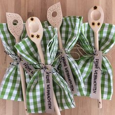 four wooden spoons wrapped in green and white checkered fabric with words on them