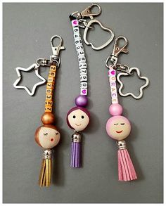 three keychains with different designs on them, one has a girl and the other is a boy