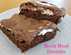 two chocolate brownies with frosting on a white plate and the words rocky road brownies