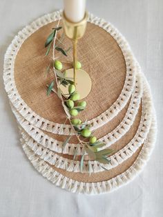 three plates with olives on them and a candle in the middle one is white