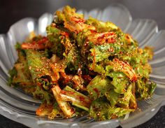 a glass bowl filled with lots of green vegetables