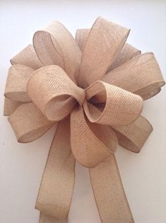 a close up of a large bow on a white wall with burlocked fabric