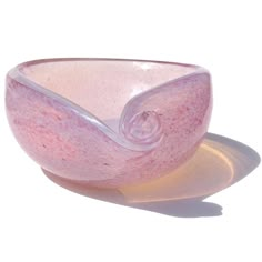 a pink glass bowl sitting on top of a white plate