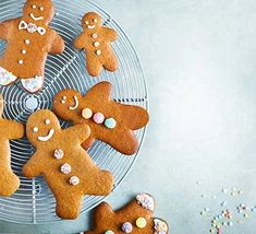 several decorated ginger cookies on a cooling rack