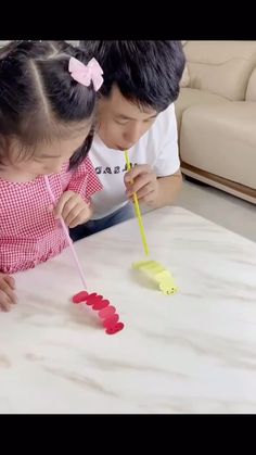 two children are playing with toothbrushes on the table