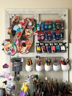 the wall is filled with art supplies and crafting supplies, including paintbrushes