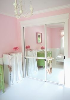 a room with pink walls and white furniture