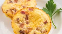 two frittatas on a white plate with some parsley next to it